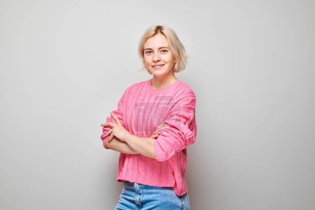 Photo for Portrait Caucasian young blond woman smiling joyfully isolated on white studio background. Happy girl in pink sweater with glad face expression - Royalty Free Image