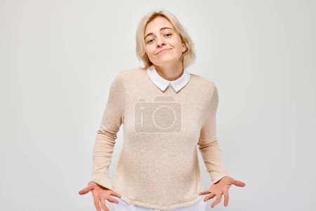 Téléchargez les photos : Portrait d'une étudiante montrant des poches vides isolées sur fond de studio blanc. Crise financière, pas de concept monétaire - en image libre de droit