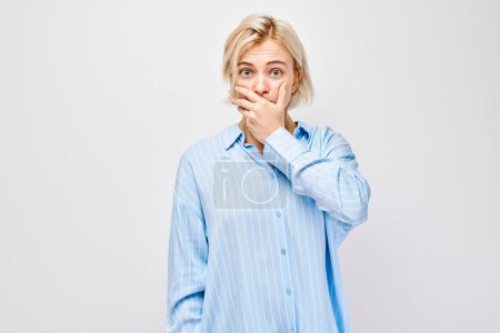Photo for Portrait of a girl covering her mouth with hand isolated on white studio background. Bad breath concept, sweat smel - Royalty Free Image