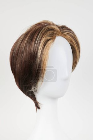 Téléchargez les photos : Perruque brune foncée à l'aspect naturel sur tête de mannequin blanche. Cheveux bruns courts sur le porte-perruque en plastique isolé sur fond blanc - en image libre de droit