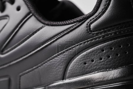 One black leather men's sneaker close-up details