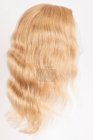 Téléchargez les photos : Perruque blonde naturelle sur tête de mannequin blanche. Cheveux longs sur le support de perruque en plastique isolé sur fond blanc, vie latérale - en image libre de droit