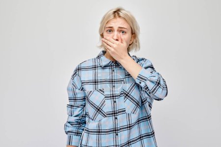 Photo for Portrait of a girl covering her mouth with hand isolated on white studio background. Bad breath concept, sweat smel - Royalty Free Image