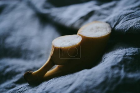 Foto de Primer plano de un ramo de plátanos sobre un fondo de tela oscura - Imagen libre de derechos