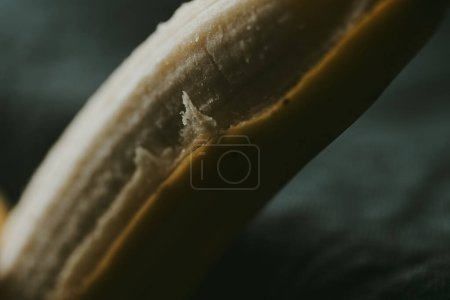 Téléchargez les photos : Gros plan de bananes pelées sur un fond sombre - en image libre de droit