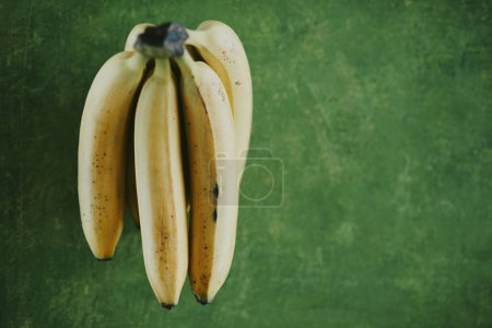 Téléchargez les photos : Gros plan des bananes sur fond vert - en image libre de droit