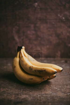 Foto de Primer plano de un ramo de plátanos sobre un fondo de textura marrón - Imagen libre de derechos