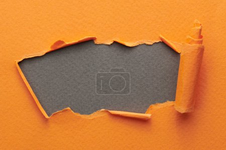 Foto de Marco de papel rasgado con bordes rotos. Ventana para texto con espacio de copia de color gris anaranjado, fragmentos de páginas de cuaderno. Fondo abstracto - Imagen libre de derechos