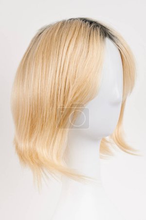 Photo for Natural looking blonde fair wig on white mannequin head. Short hair cut on the plastic wig holder isolated on white backgroun - Royalty Free Image