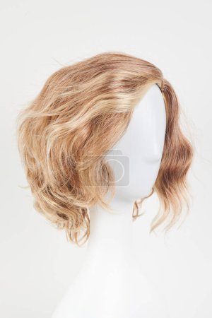 Téléchargez les photos : Perruque blonde blonde naturelle sur tête de mannequin blanche. Cheveux courts coupés sur le porte-perruque en plastique isolé sur fond blanc - en image libre de droit