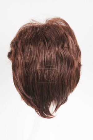 Photo for Natural looking dark brunet wig on white mannequin head. Short brown hair on the plastic wig holder isolated on white background, back vie - Royalty Free Image