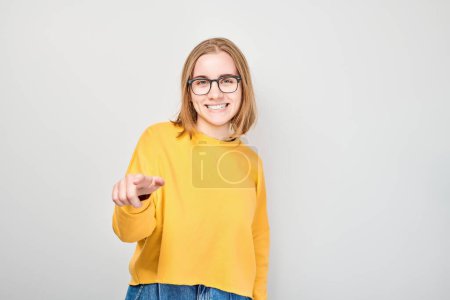 Photo for Portrait of confident student girl chooses you points finger at camera isolated on white studio background. Welcome gesture, join our team concept - Royalty Free Image