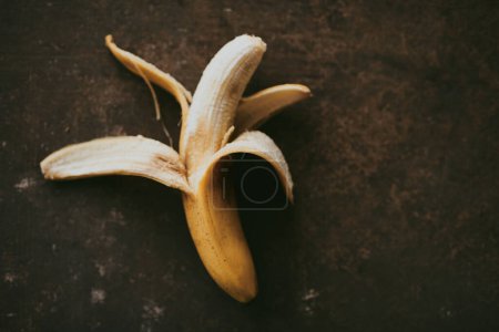 Téléchargez les photos : Gros plan de bananes pelées sur un fond sombre - en image libre de droit