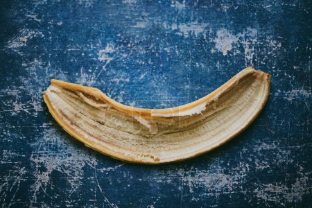 Téléchargez les photos : Gros plan de la peau de banane sur fond texturé bleu - en image libre de droit
