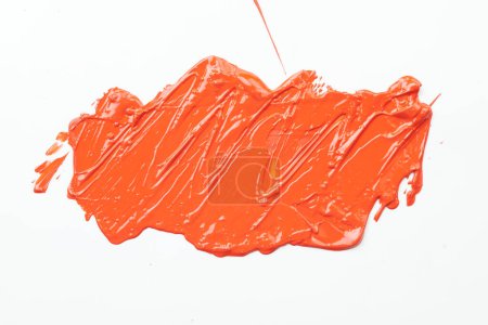 Téléchargez les photos : Tache de peinture acrylique, coup de pinceau chaotique, tache coulant sur fond de papier blanc. Fond de couleur orange créatif, fluide ar - en image libre de droit