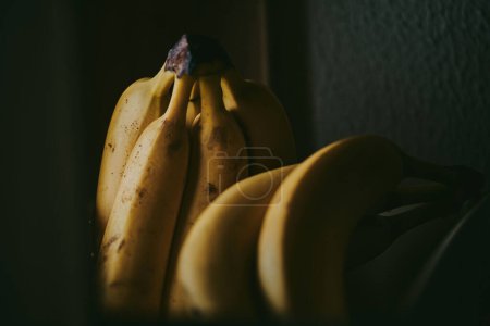 Foto de Primer plano de un ramo de plátanos en una canasta sobre un fondo de mesa - Imagen libre de derechos