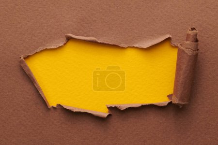 Photo for Frame of ripped paper with torn edges. Window for text with copy space yellow brown colors, shreds of notebook pages. Abstract backgroun - Royalty Free Image