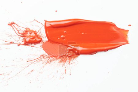 Foto de Mancha de pintura acrílica, pincelada caótica, mancha que fluye sobre fondo de papel blanco. Fondo creativo de color naranja, ar fluido - Imagen libre de derechos