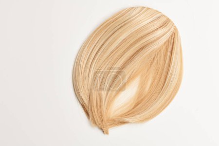 Téléchargez les photos : Cheveux naturels brillants, belles boucles blondes isolées sur fond blanc avec espace de copie - en image libre de droit