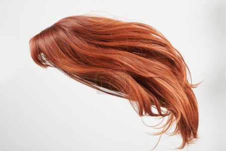 Téléchargez les photos : Cheveux naturels brillants, boucles rouges isolées sur fond blanc avec espace de copie - en image libre de droit