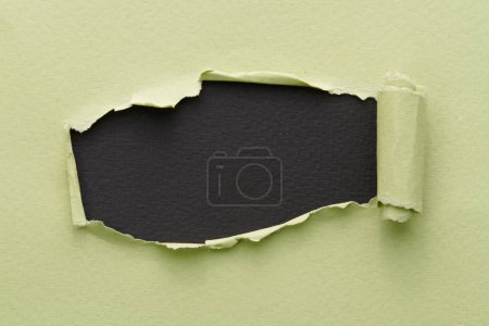 Photo for Frame of ripped paper with torn edges. Window for text with copy space black green colors, shreds of notebook pages. Abstract backgroun - Royalty Free Image