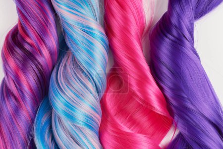Téléchargez les photos : Cheveux naturels brillants de différentes couleurs vives, perruque cosplay sur fond blanc - en image libre de droit