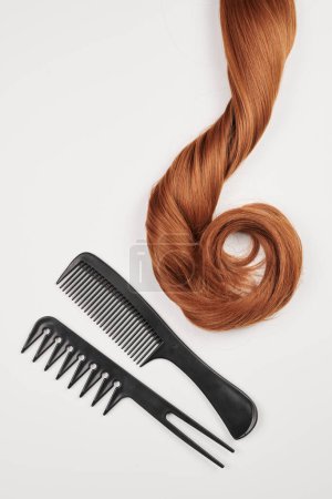 Téléchargez les photos : Outils de coiffure close-up isolé sur fond blanc. Boucles de cheveux et ensemble de peignes, clips, épingles à cheveux, concept de salon de beauté des cheveux - en image libre de droit