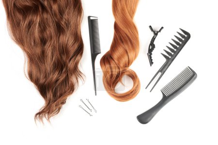 Téléchargez les photos : Outils de coiffure close-up isolé sur fond blanc. Boucles de cheveux et ensemble de peignes, clips, épingles à cheveux, concept de salon de beauté des cheveux - en image libre de droit