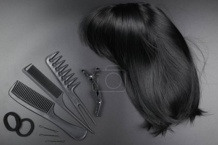 Photo for Hairdresser tools close-up isolated on black background. Curls of dark brunette hair and a set of combs, clips, hairpins, hair beauty salon concept - Royalty Free Image