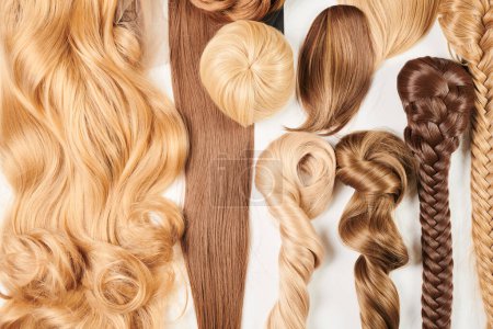 Téléchargez les photos : Cheveux brillants à l'aspect naturel, bouquet de différentes couleurs boucles et perruques isolées sur fond blanc - en image libre de droit