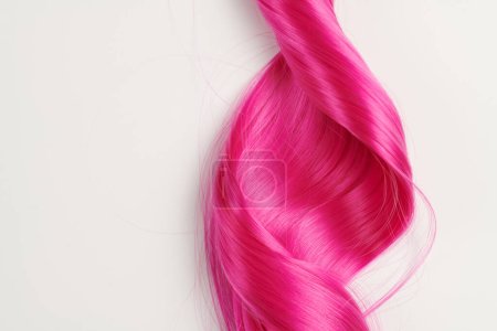 Foto de Cabello brillante de aspecto natural de color rosa brillante, peluca cosplay sobre un fondo blanco - Imagen libre de derechos