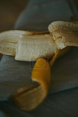Photo for Close-up of peeled sliced banana on wooden table background - Royalty Free Image