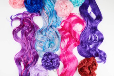 Téléchargez les photos : Cheveux naturels brillants de différentes couleurs vives, perruque cosplay sur fond blanc - en image libre de droit