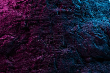 Photo for Black stone texture in pink blue neon lighting, dark abstract background. Natural mineral rock close up details, empty backdrop with copy space for design - Royalty Free Image