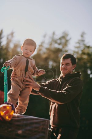 Foto de Retrato de padre joven con hijo. Feliz paternidad, hombre jugando con el niño en el soleado día de otoño - Imagen libre de derechos