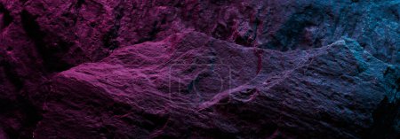 Photo for Black stone texture in pink blue neon lighting, dark abstract background. Natural mineral rock close up details, empty backdrop with copy space for design - Royalty Free Image