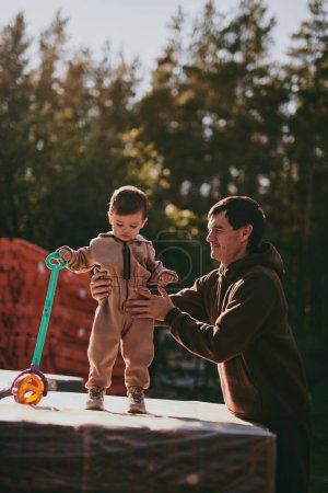 Téléchargez les photos : Portrait de jeune père avec fils. Bonne paternité, homme jouant avec le garçon le jour ensoleillé d'automne - en image libre de droit