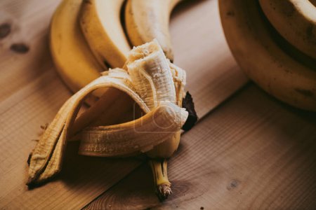 Téléchargez les photos : Gros plan de banane pelée tranchée sur fond de table en bois - en image libre de droit