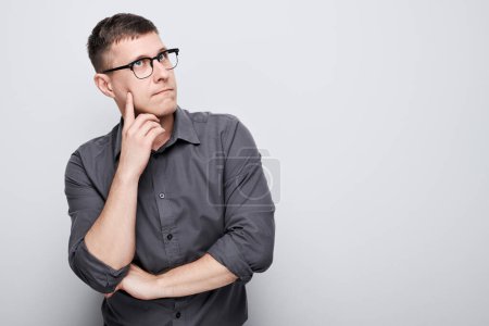 Photo for Portrait of clever man in shirt touching chin thinks doubts chooses isolated on white studio background with copy space - Royalty Free Image