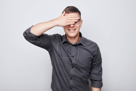 Photo for Portrait of young businessman covering eyes with hand isolated on white studio backgroun - Royalty Free Image