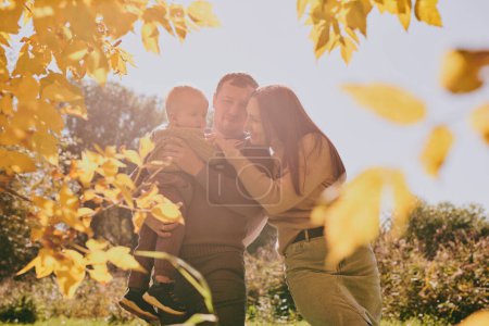 Téléchargez les photos : Portrait heureux maman de famille papa et fils s'amusent et aiment passer du temps ensemble dans le parc d'automne par une journée ensoleillée. Amour et loyauté, jeunes parents - en image libre de droit