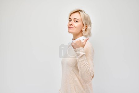 Photo for Young blond woman in casual pointing aside finger, demonstrating empty space for product or text isolated on white studio backgroun - Royalty Free Image