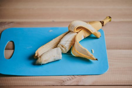 Foto de Primer plano de plátano pelado en rodajas sobre fondo de mesa de madera - Imagen libre de derechos