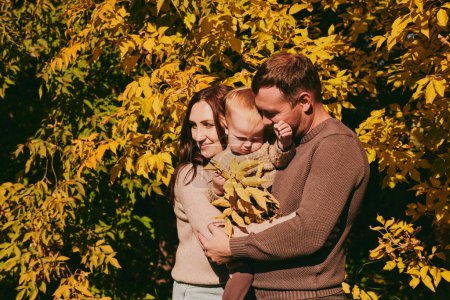 Photo for Portrait happy family mom dad and son having fun and enjoying spending time together in autumn park on sunny day. Love and loyalty, young parents - Royalty Free Image