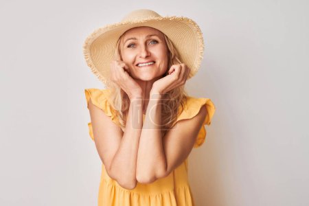 Foto de Retrato mujer adulta sonriendo alegremente tocando cara feliz aislado en fondo de estudio blanco, banne publicidad - Imagen libre de derechos