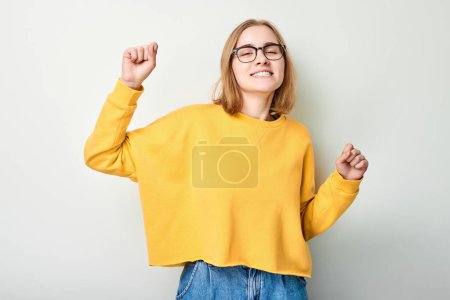 Photo for Portrait of smiling face girl clenching fists and rejoicing, celebrating victory isolated on white studio background, advertising banne - Royalty Free Image