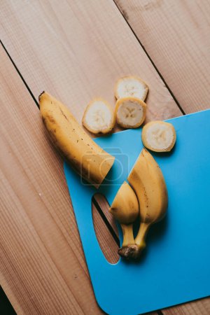 Téléchargez les photos : Gros plan de banane pelée tranchée sur fond de table en bois - en image libre de droit