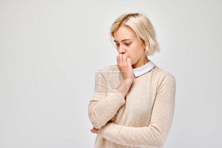 Photo for Portrait of girl with sad face worried, biting nails on white background. Nerves, stress, uncertainty concep - Royalty Free Image