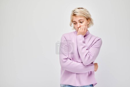 Foto de Retrato de chica con cara triste preocupada, mordiendo clavos sobre fondo blanco. Nervios, estrés, incertidumbre concep - Imagen libre de derechos