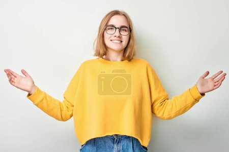 Foto de Retrato estudiante chica feliz cara sonriendo alegremente con las palmas levantadas y la boca abierta conmocionado aislado en fondo blanco estudio - Imagen libre de derechos